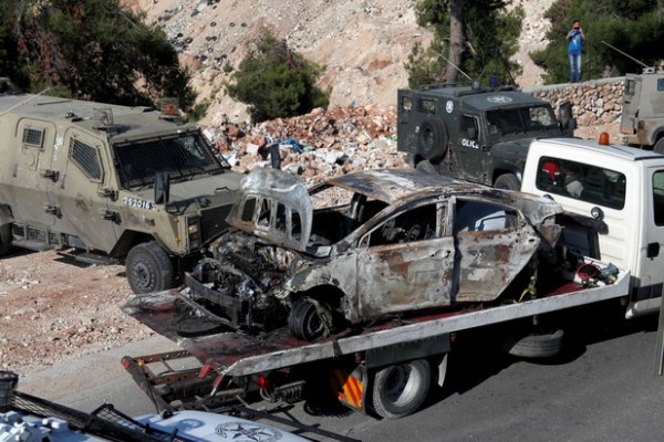 Des soldats israéliens sécurisent la zone autour d’une voiture carbonisée près d’Hébron, en Cisjordanie, le 13 juin, après que trois adolescents israéliens furent portés disparus la veille. (Mamoun Wazwaz/APA Images)  