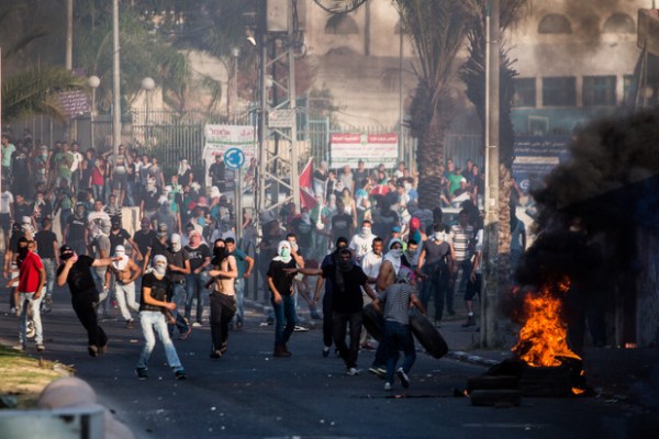 Des manifestants dans la ville palestinienne d’Arara dans le nord de ce qui est actuellement Israël lancent des pierres sur la police israélienne lors d’une manifestation après l’assassinat de Muhammad Abu Khudair, le 5 juillet. (Yotam Ronen/ActiveStills).